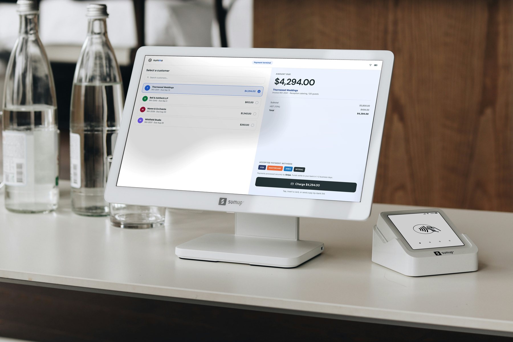 A countertop payment terminal running Nummo, showing an amount due and accepted card payment methods